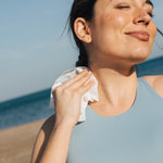 Woman using shower sheet to wipe neck
